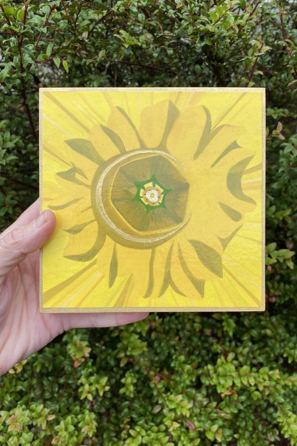 Daffodil Moon painting by Amy Daileda reproduced on a wood block. Bright yellow painting with greenery in the background.